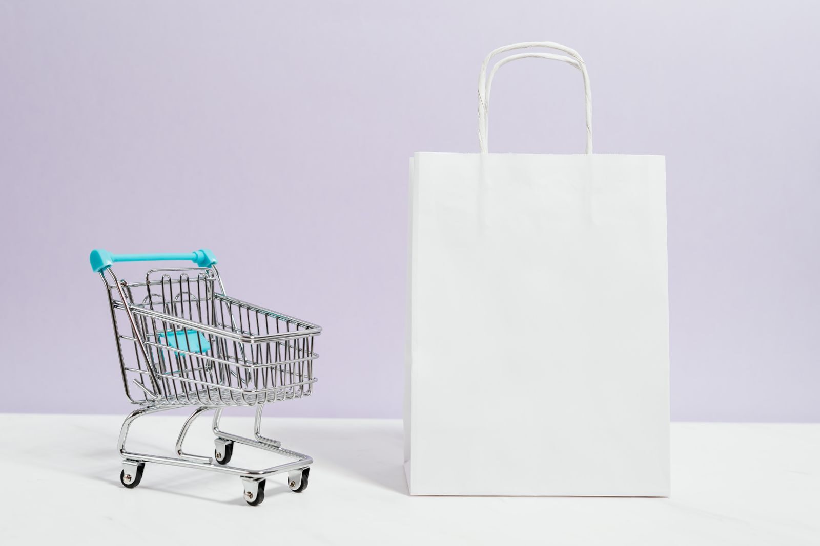 Miniature shopping cart and shopping bag representing online retail