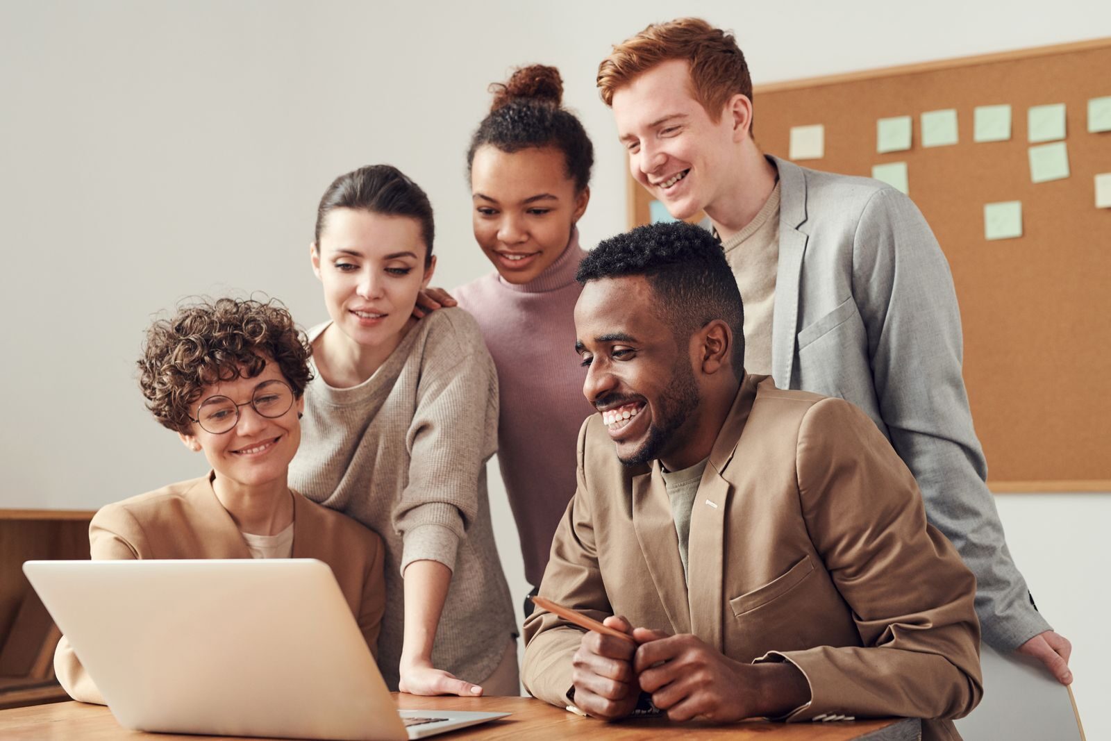 Colleagues gathered around a laptop reviewing a project